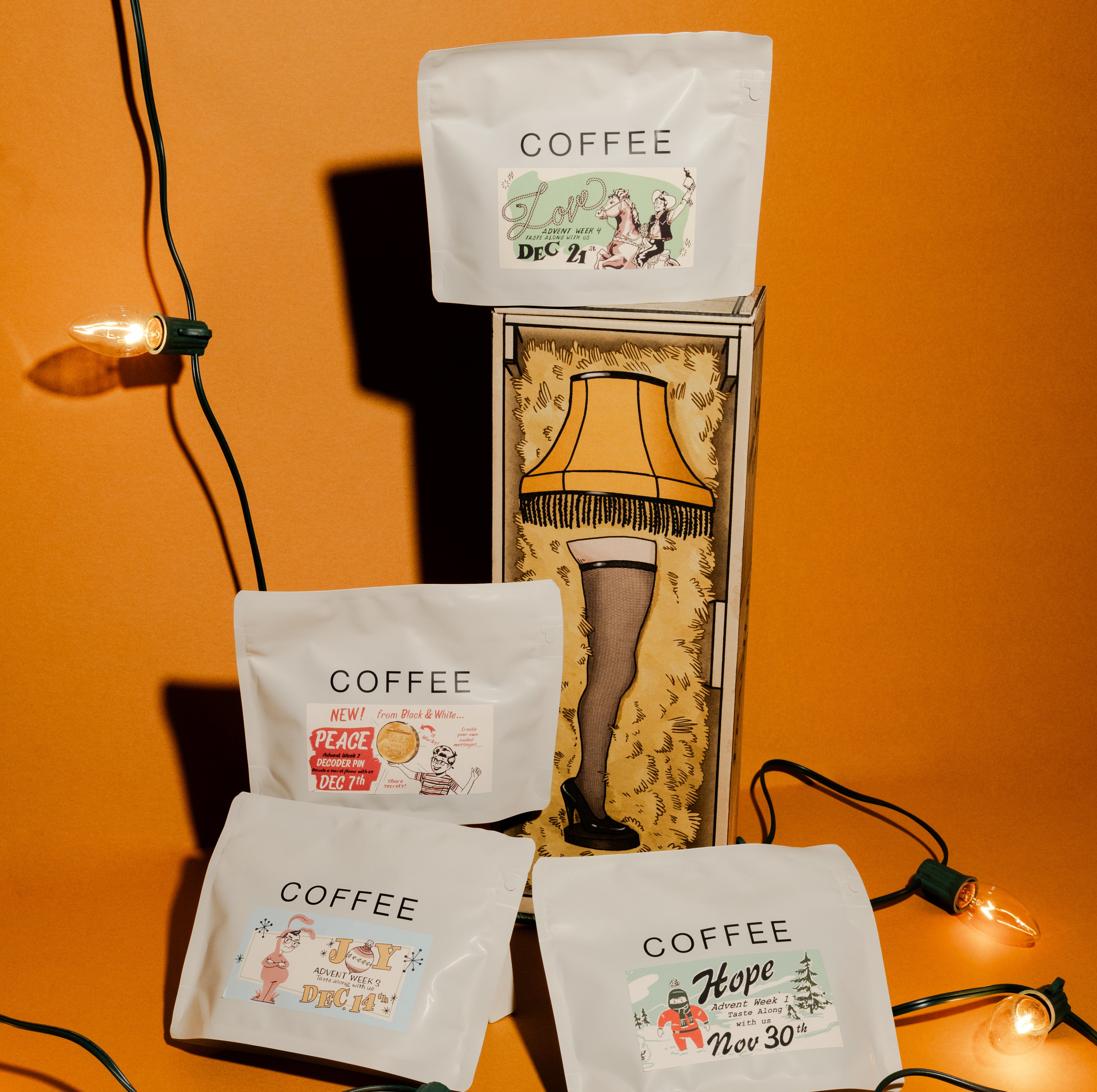2025 B&W Advent Calendar features four holiday-themed coffee pouches with tags: Hope, Joy, Peace, Love, arranged around a decorative “leg lamp” box.