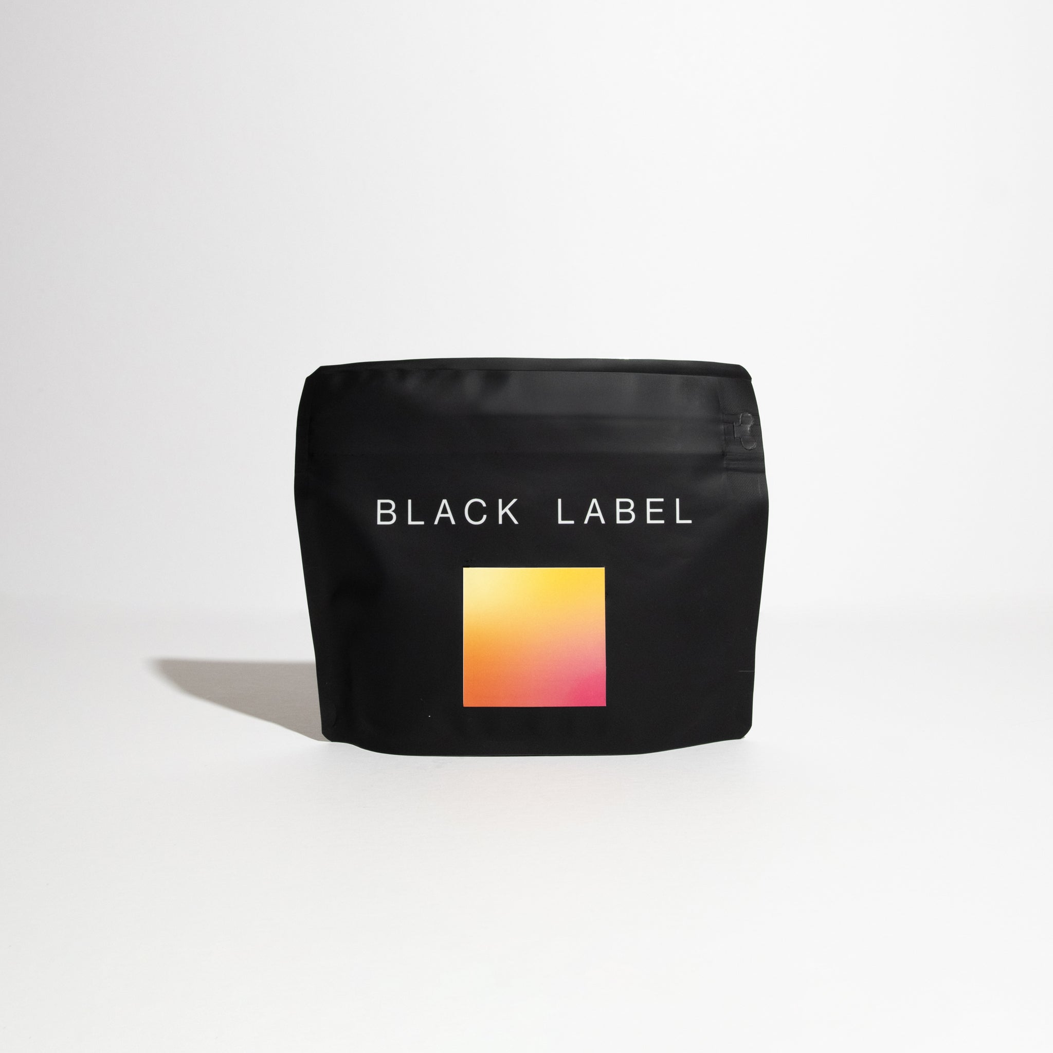 Matte-black pouch labeled BLACK LABEL, featuring a vibrant gradient graphic, containing Hacienda La Esmeralda - Jaramillo Natural Gesha, a specialty Panamanian coffee.