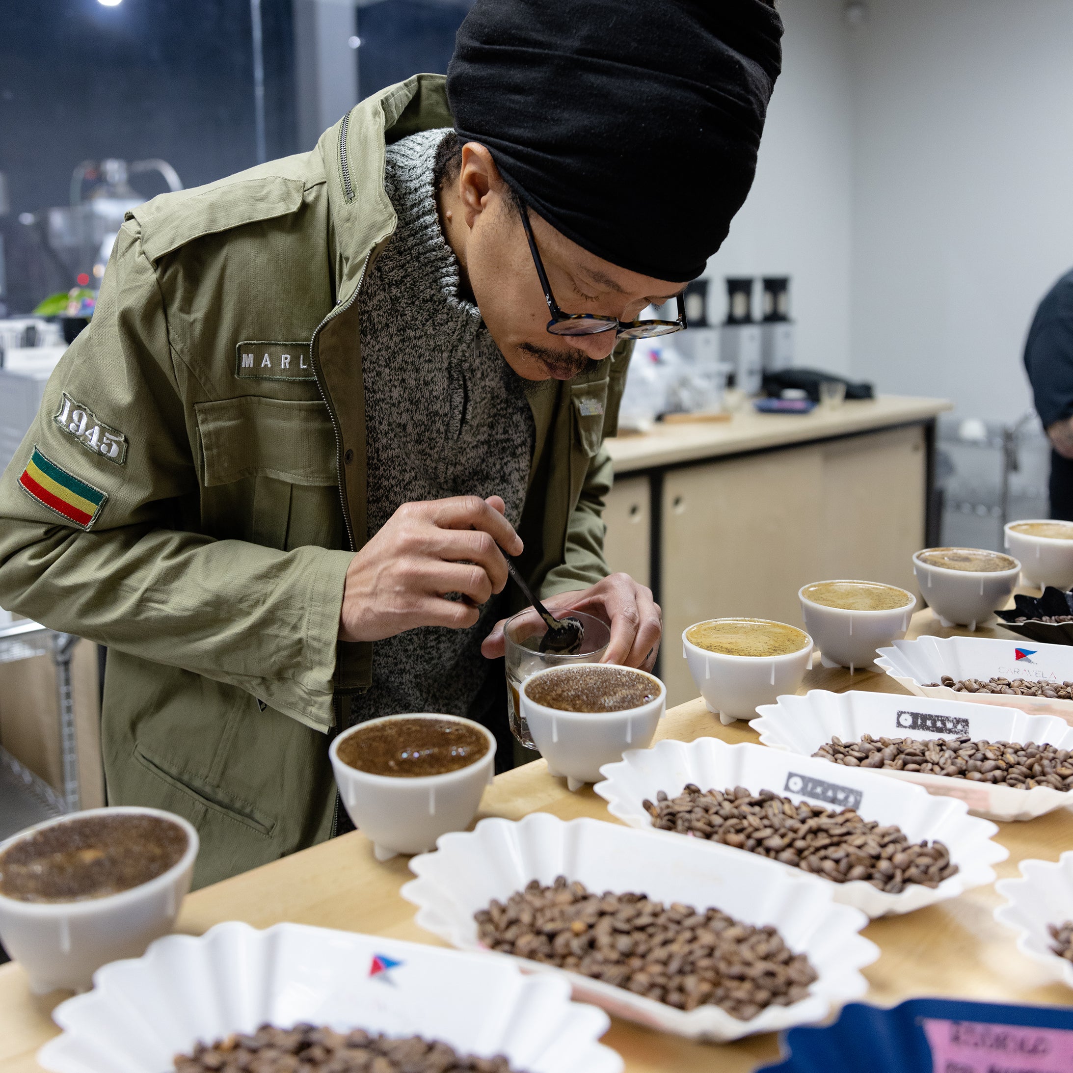 A man cupping coffee in a modern cupping lab.