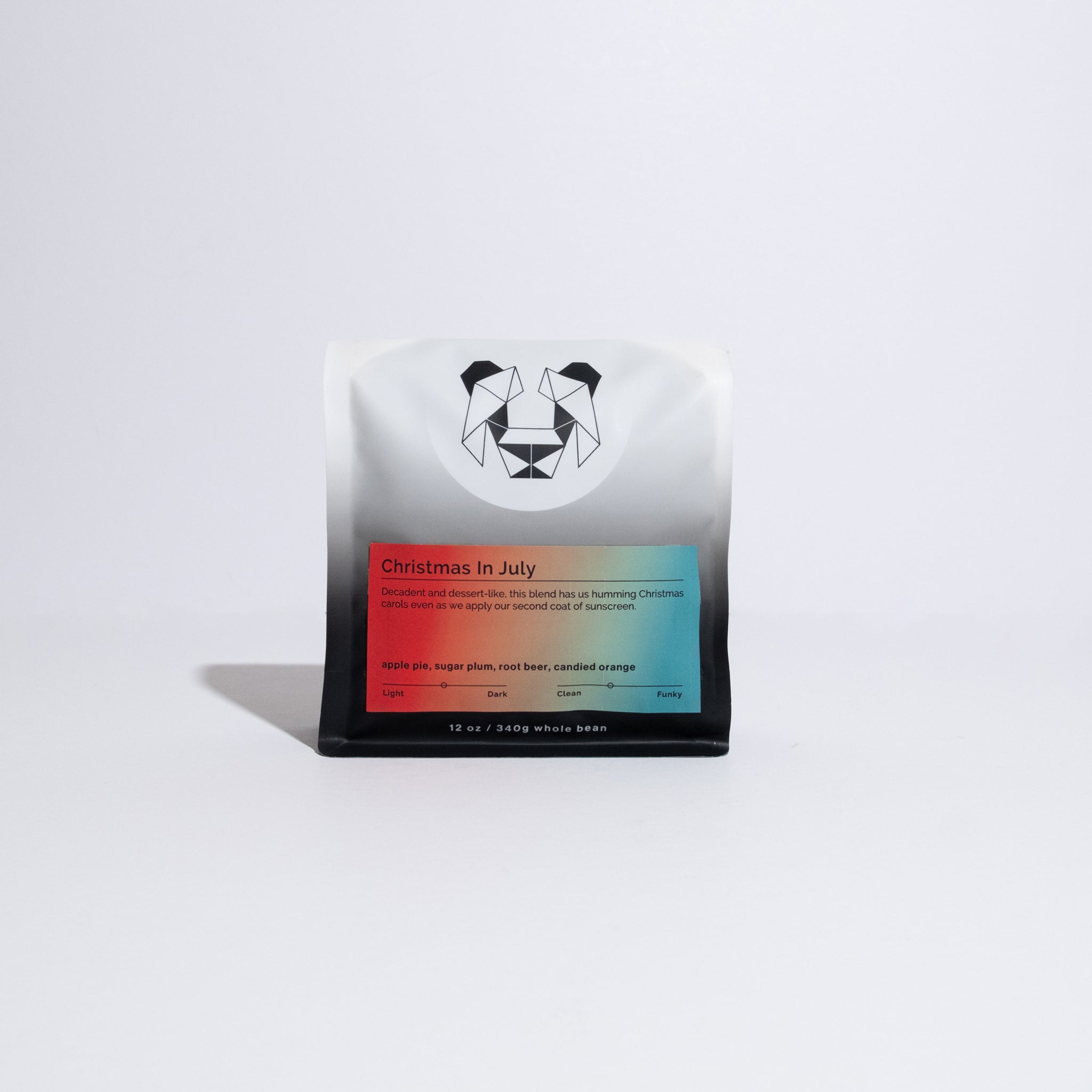 Close-up of Christmas in July coffee packaging featuring a dog logo, emphasizing festive flavors like cinnamon and apple pie for a summer celebration.