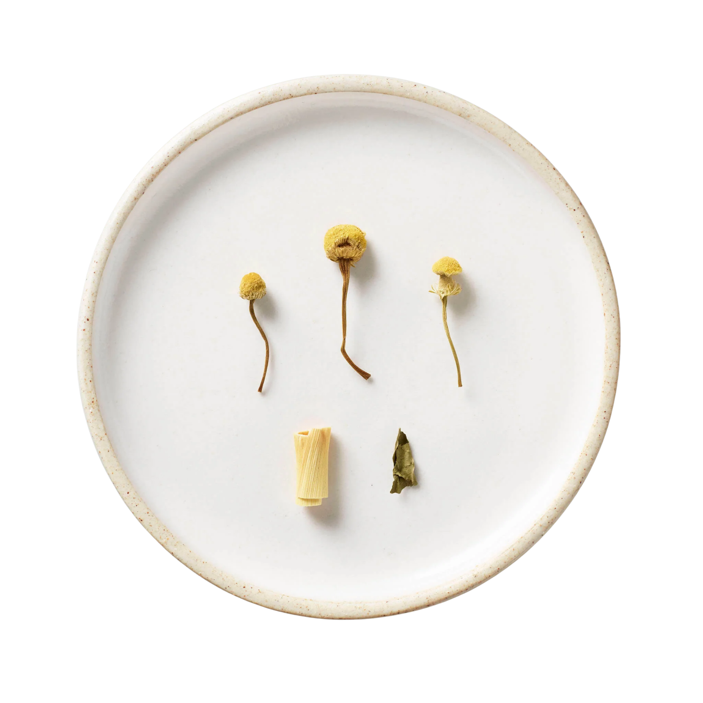 Bouquet | Tisane Blend: Overhead view of chamomile flowers, lemongrass, and a dried leaf, showcasing the key ingredients of this honey-sweet, caffeine-free tisane.