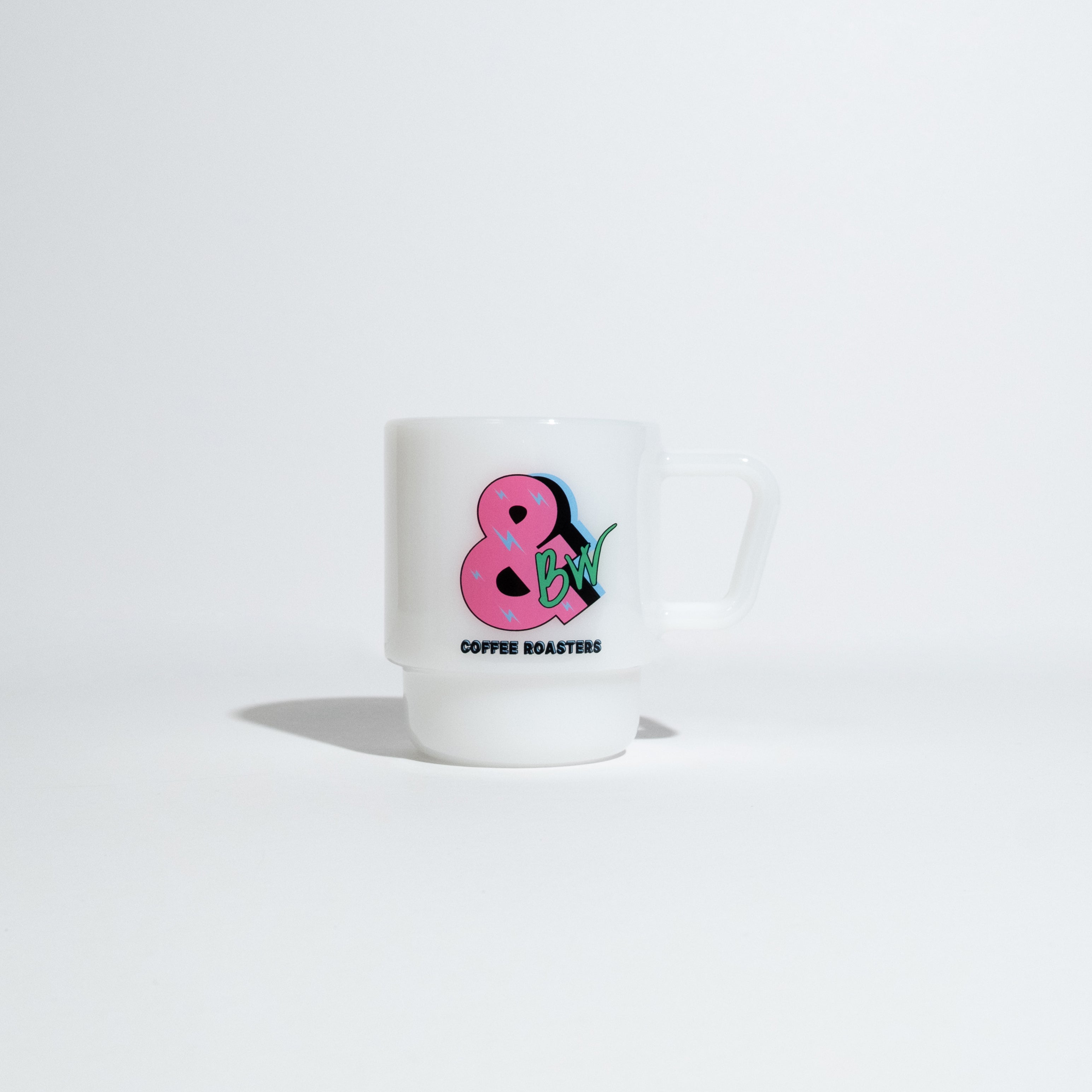 A white ceramic coffee mug with a pink ampersand and green strawberry graphic, with the text 'COFFEE ROASTERS' printed below, set against a clean white background.