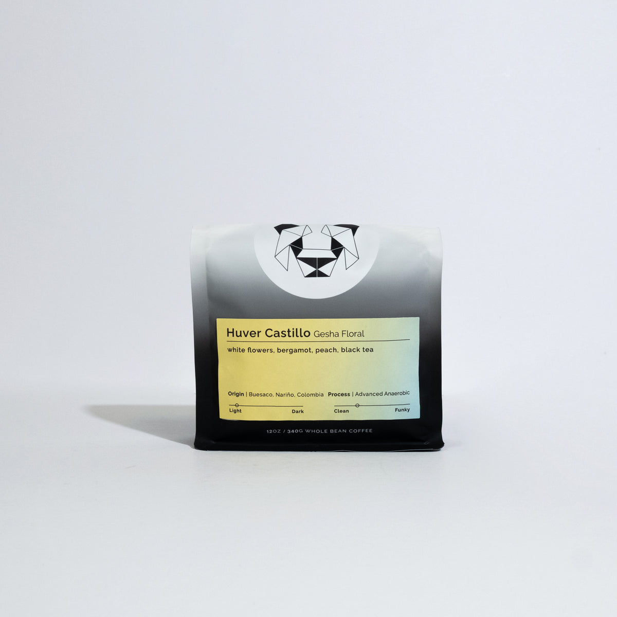 A bag of coffee on a white background with a colorful label on it that says Huver Castillo Gesha Floral and tasting notes of white flowers, bergamot, peach, and black tea.