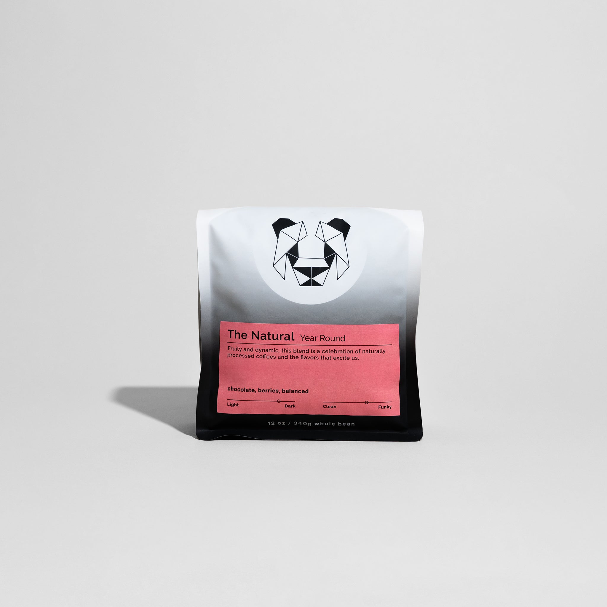 The Natural coffee bag highlighting its medium-dark roast, featuring origins from Colombia and Ethiopia with notes of red fruits, chocolate, and balanced acidity.