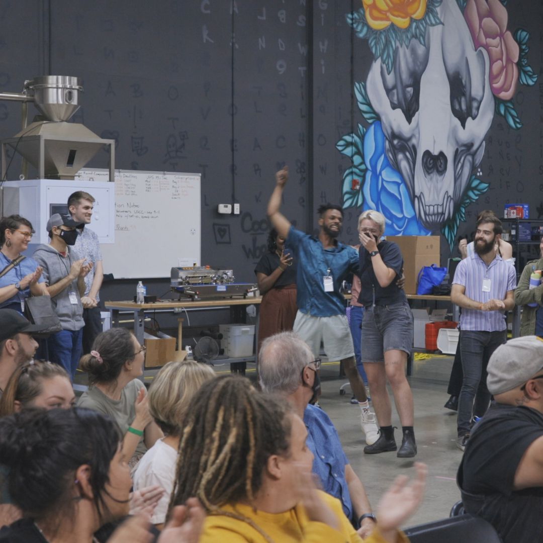 A picture of a group of coffee professionals gathered for an event with the winner of the event excited.