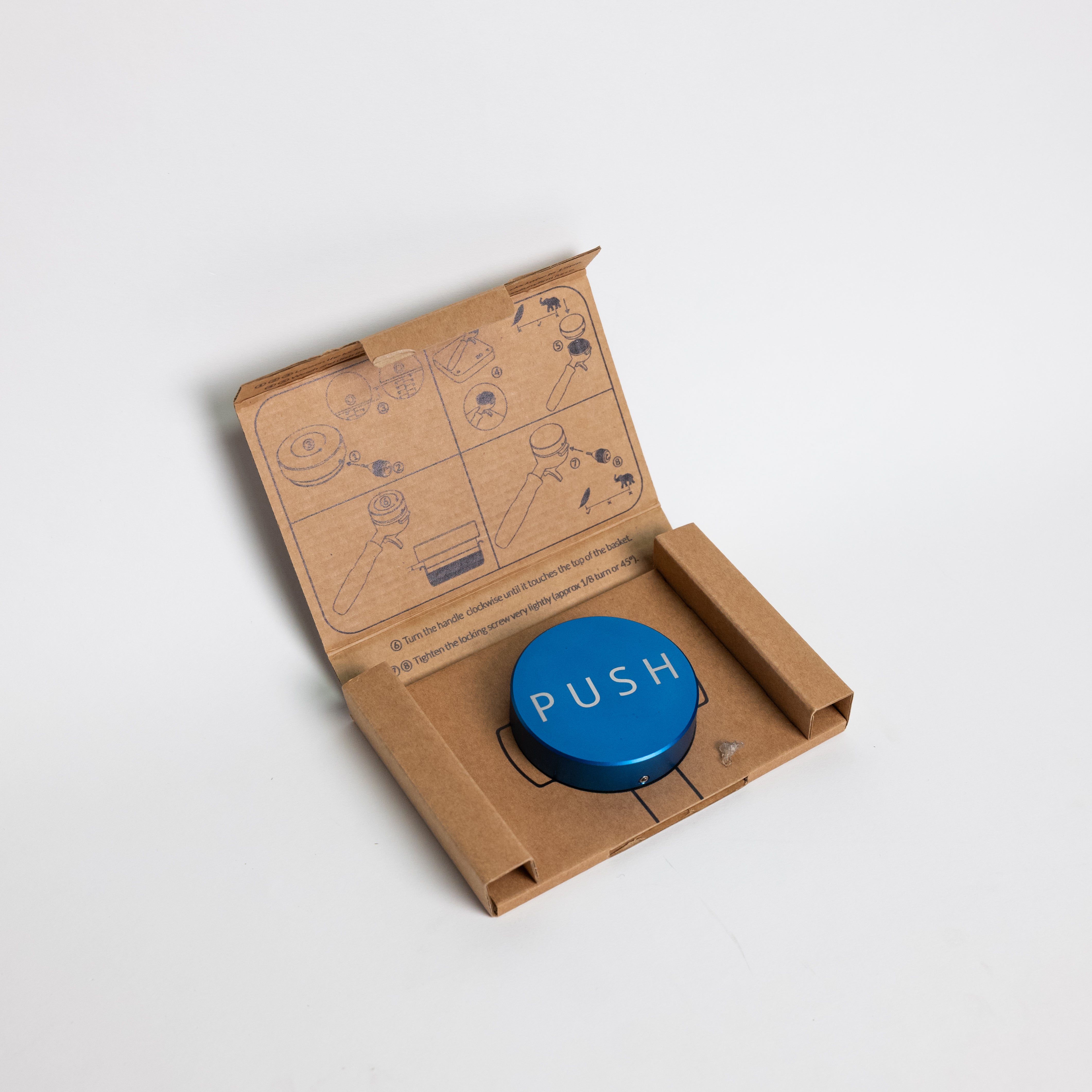 PUSH Adjustable Depth Tamper, puck-shaped, made of anodized aluminum and stainless steel, with an adjustment tool included for setting precise tamping depth.