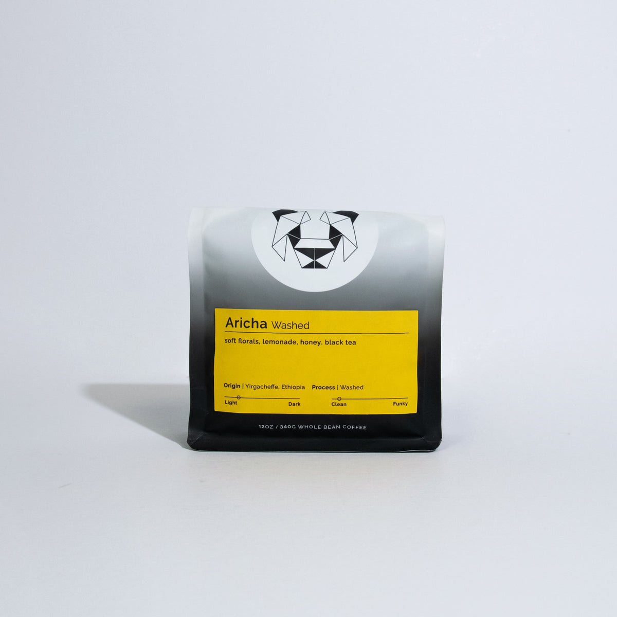 A bag of coffee on a white background with a yellow label that says Aricha Washed with tasting notes of oft florals, lemonade, honey and black tea.