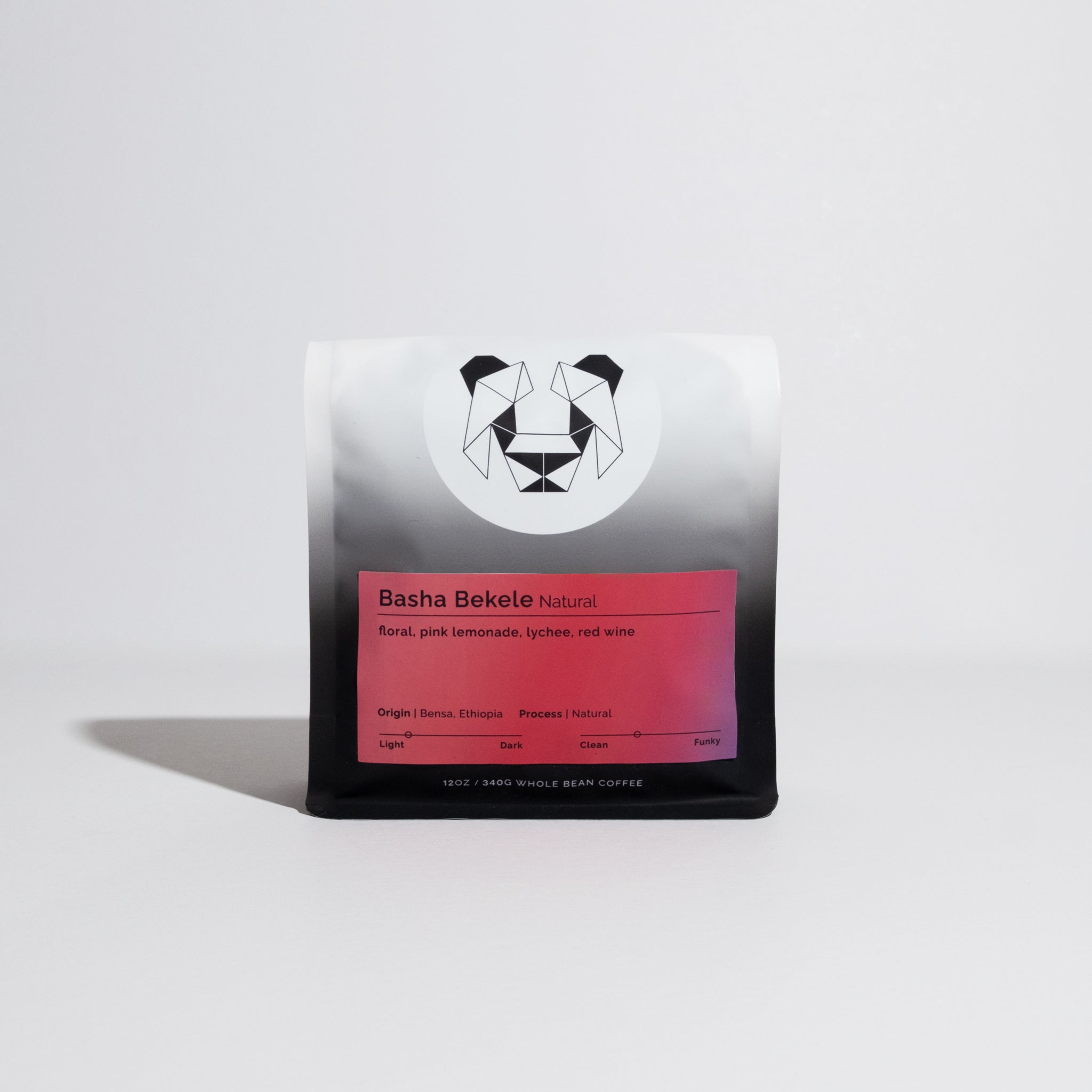 Bag of whole-bean coffee, Basha Bekele - Natural, highlighting floral, pink lemonade, lychee, red wine notes, with geometric logo and roast spectrum visible.