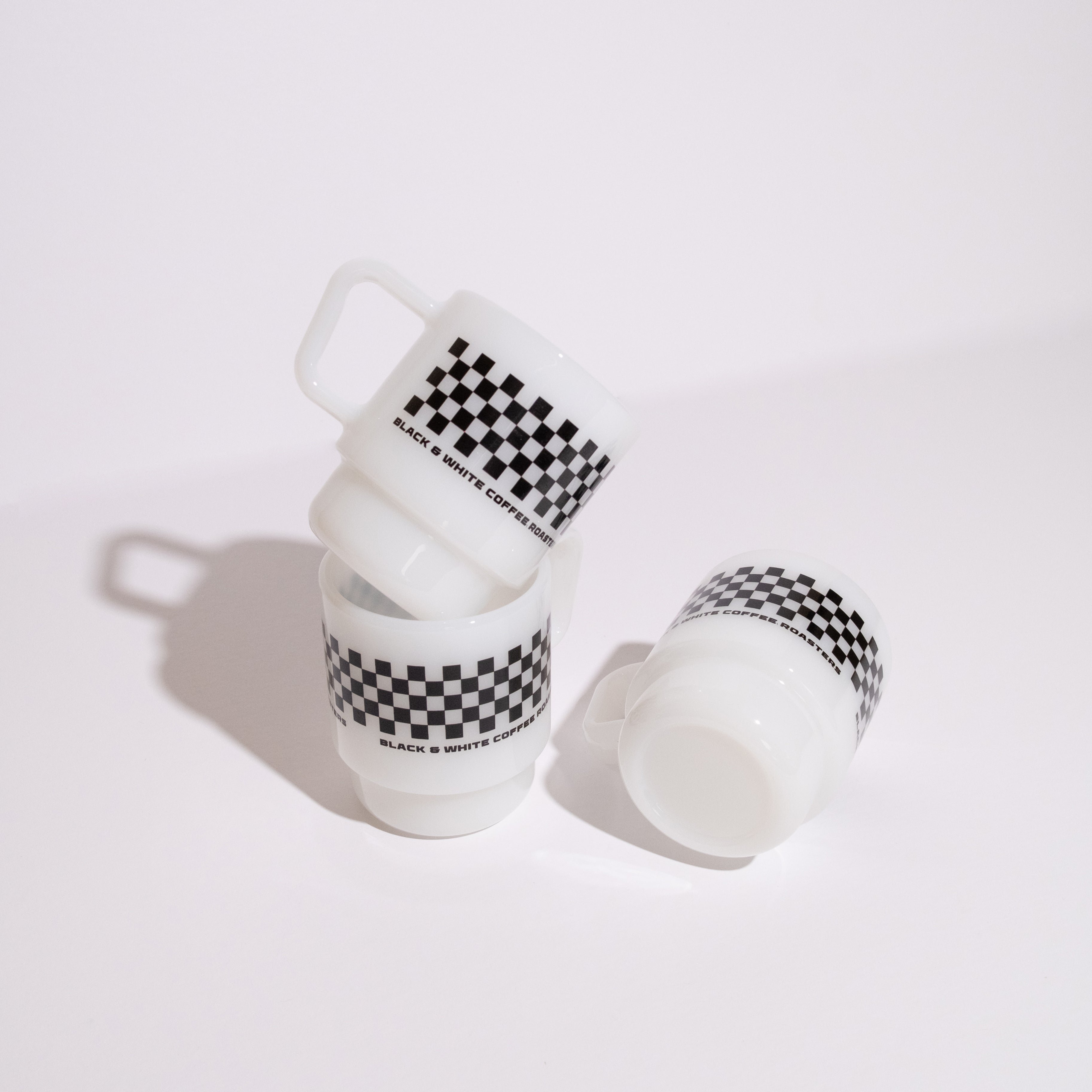 2025 Birthday Milk Glass Mug with a checkerboard stripe and BLACK & WHITE COFFEE ROASTERS text, featuring stackable design and vintage aesthetic.