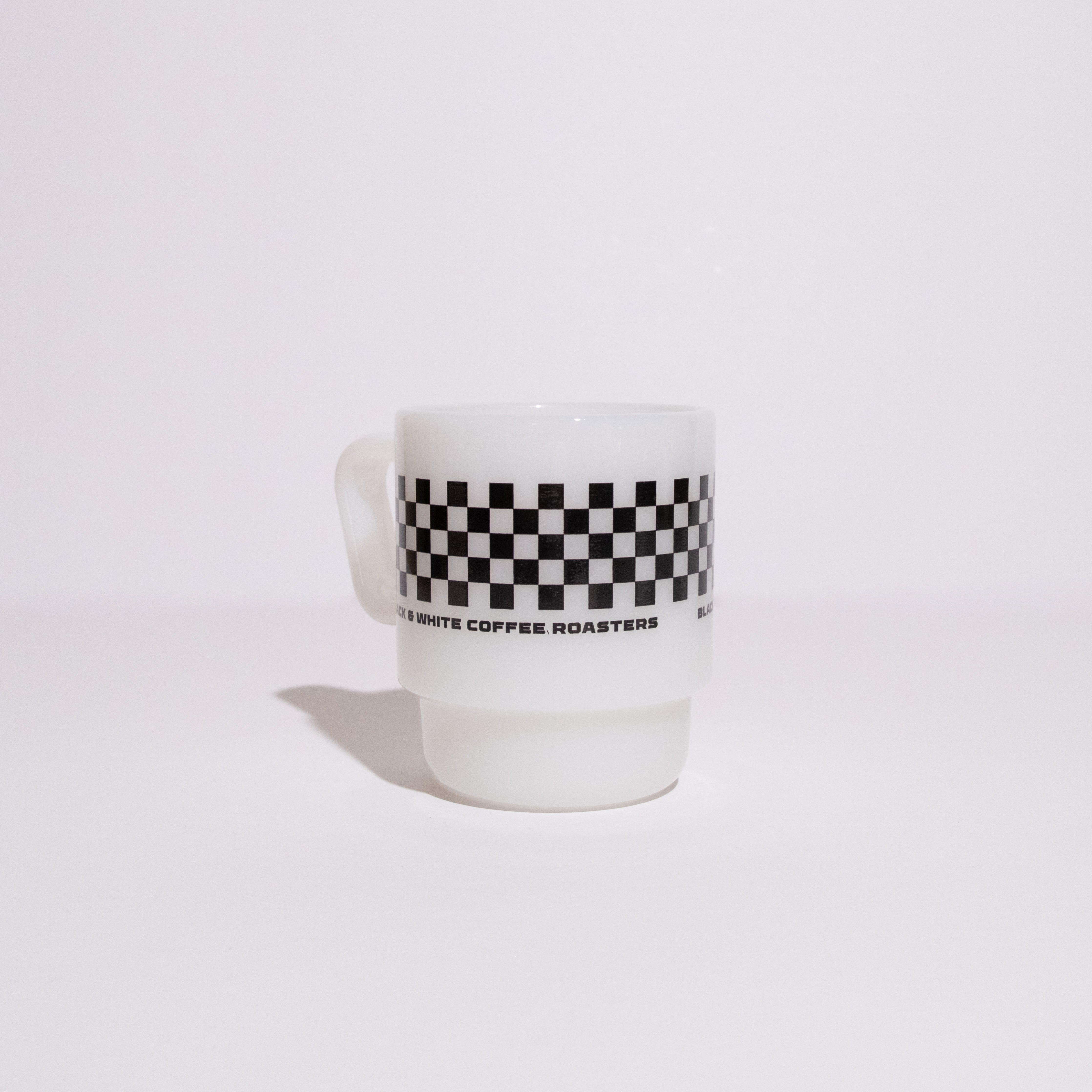 2025 Birthday Milk Glass Mug featuring a black-and-white checkerboard band and BLACK & WHITE COFFEE ROASTERS text, inspired by classic milk glass design.