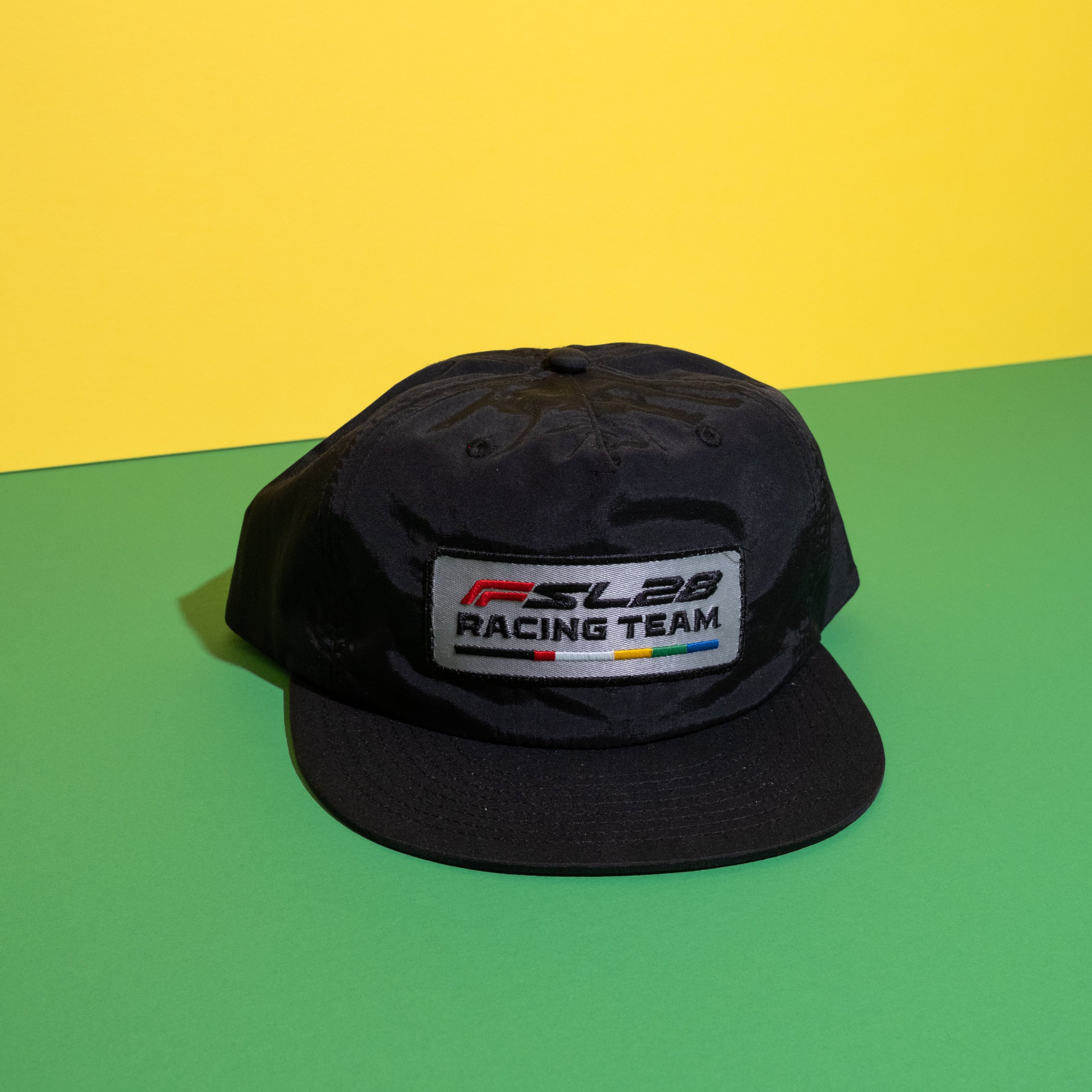 Black cap with a logo on a green and yellow background