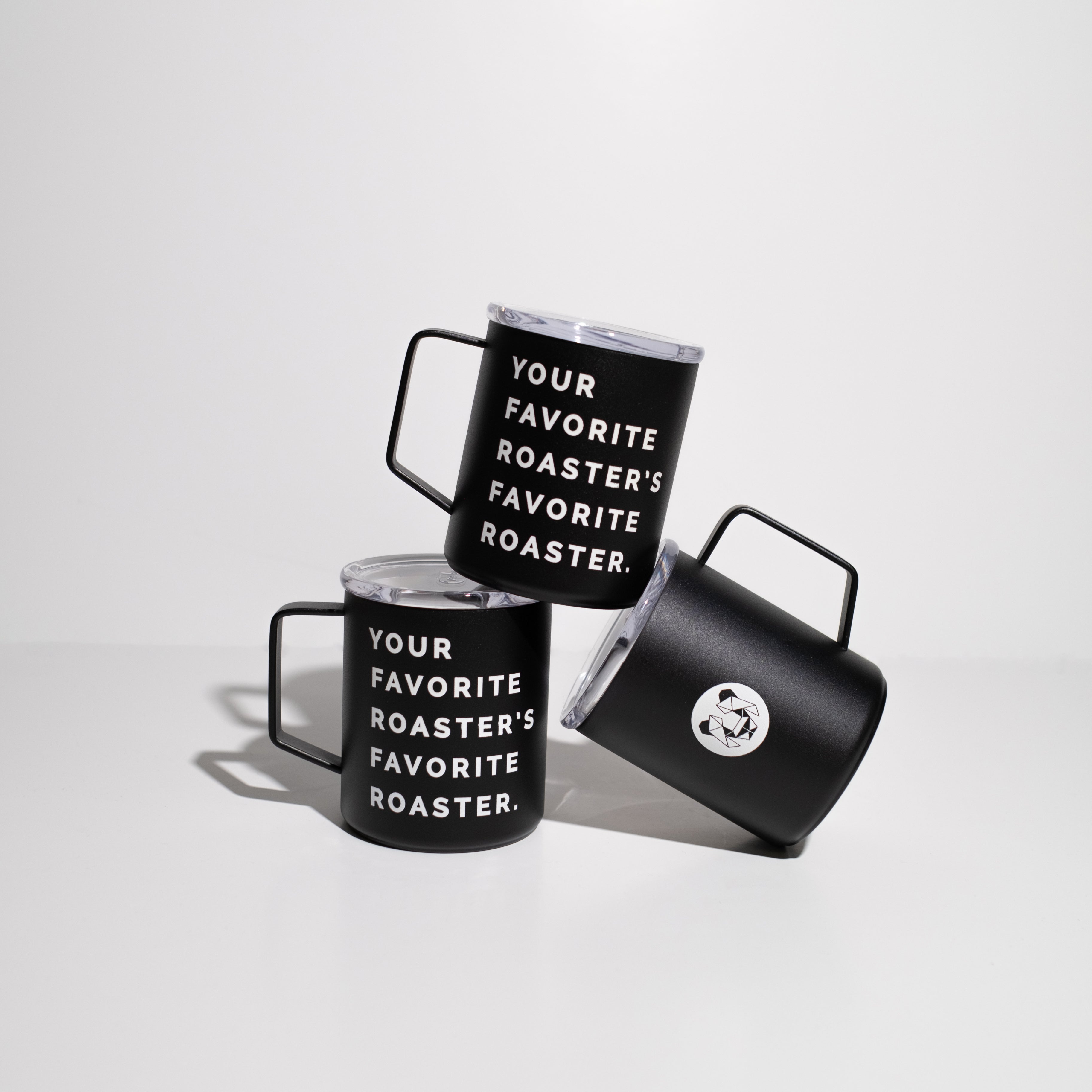 Multiple black enamel 12 ounce camp cups on a white background stacked for display. Cups have the statement, your favorite roaster, favorite roaster in white text on one side and a geometric panda on the other side.