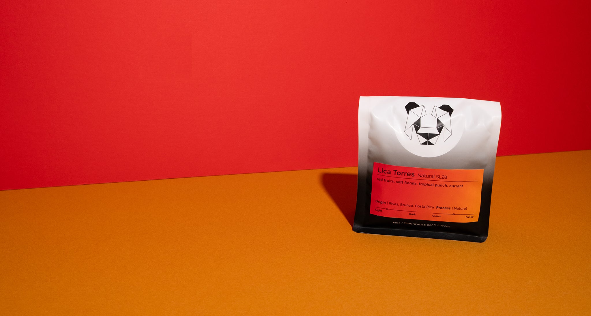 A bag of coffee on a colorful background that says Lica Torres Natural SL28 with notes of red fruits, soft florals, tropical punch, and currants.