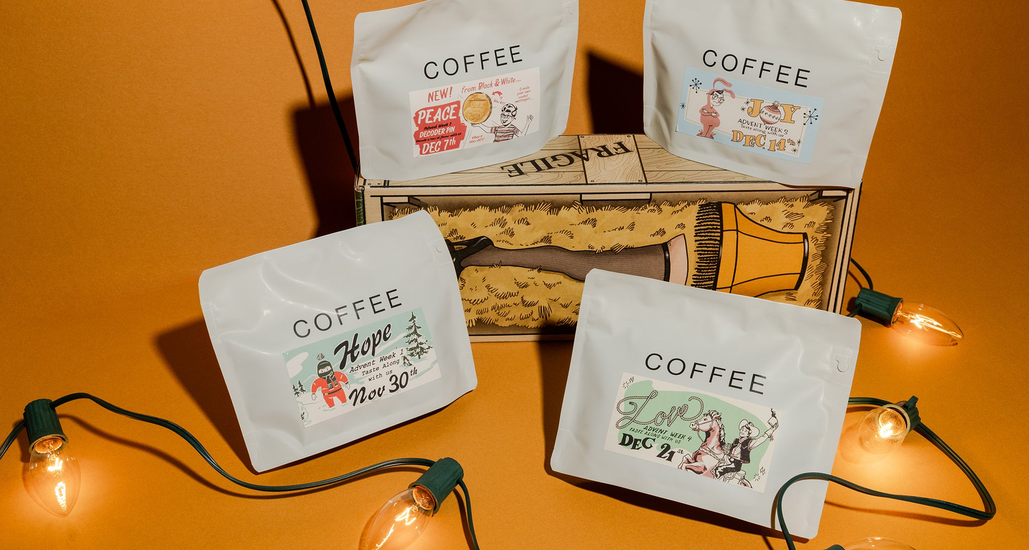Coffee bags with decorative labels on a wooden box against an orange background. The coffee labels say Peace, hope, love and joy.
