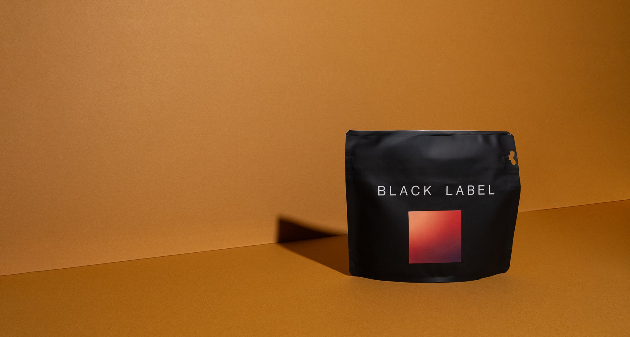 Black coffee bag with 'Black Label' branding on a brown background. This coffee is Nestor Lasso's Ombligon Natural. 