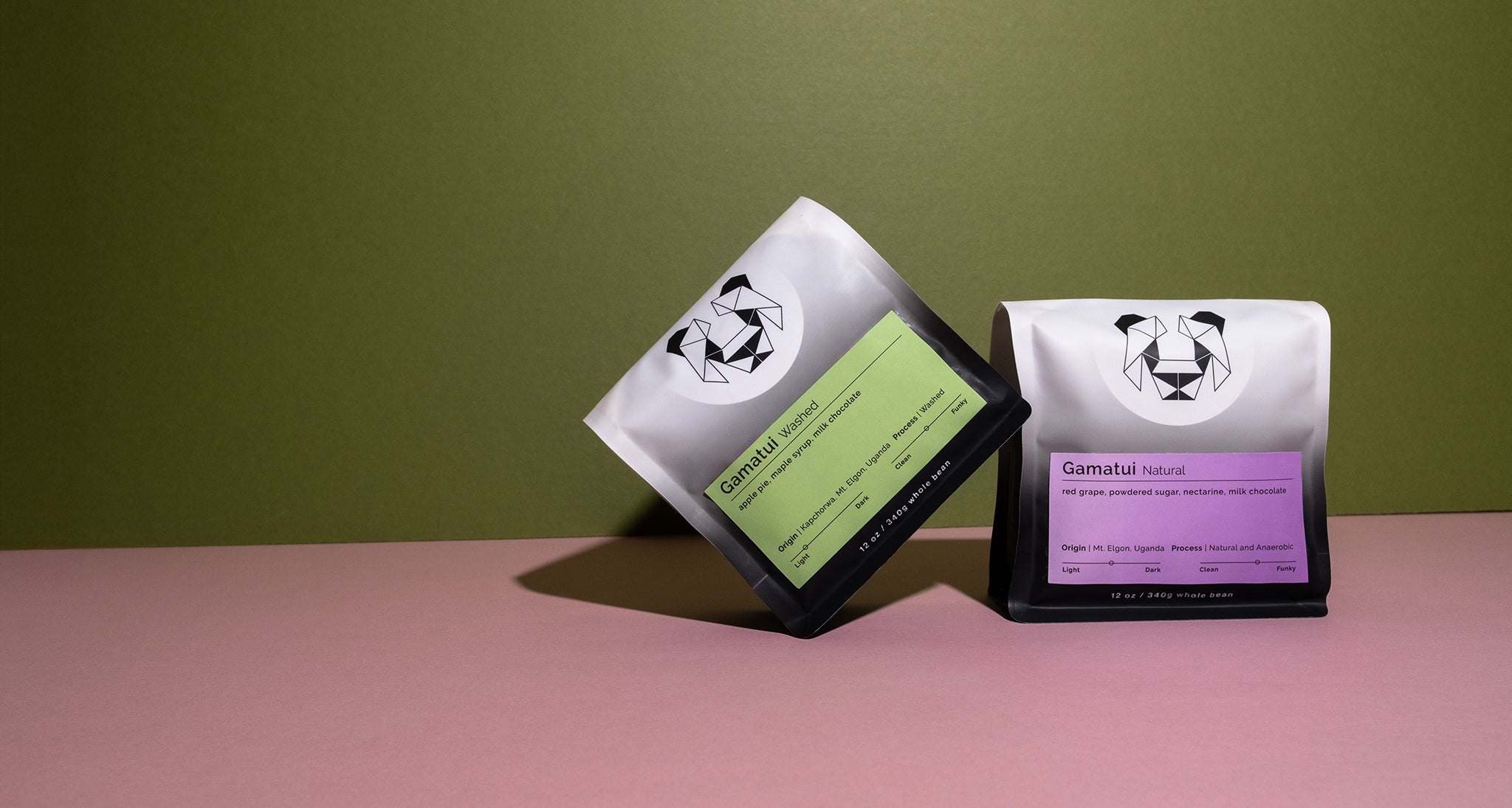 Two bags with a brand logo on a pink surface against a green background. The coffee is Gamatui Washed and Gamatui Natural from Sipi Falls, Uganda. 