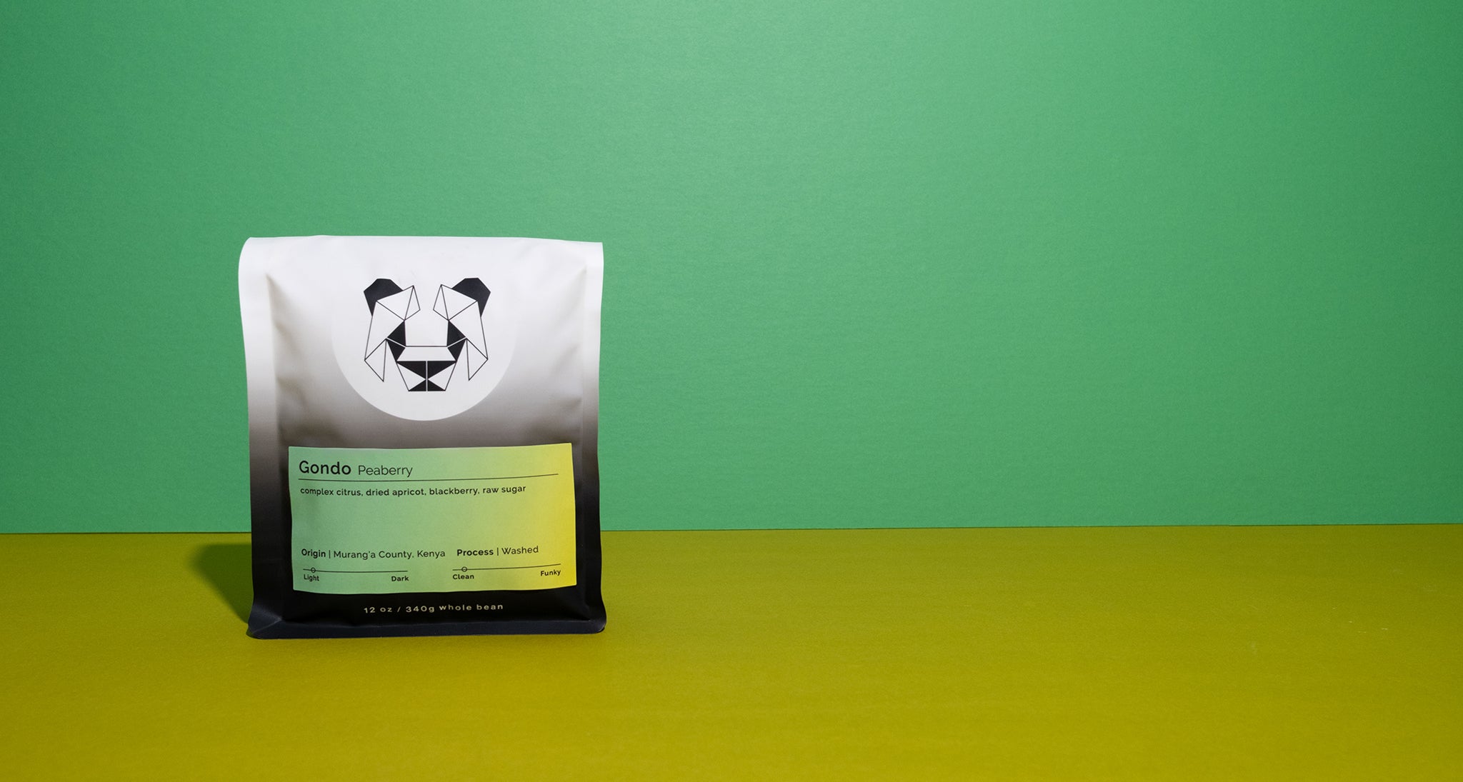 A bag of coffee on a colored background with a label that says Gondo Peaberry and notes of complex citrus, dried apricot, blackberry and raw sugar.
