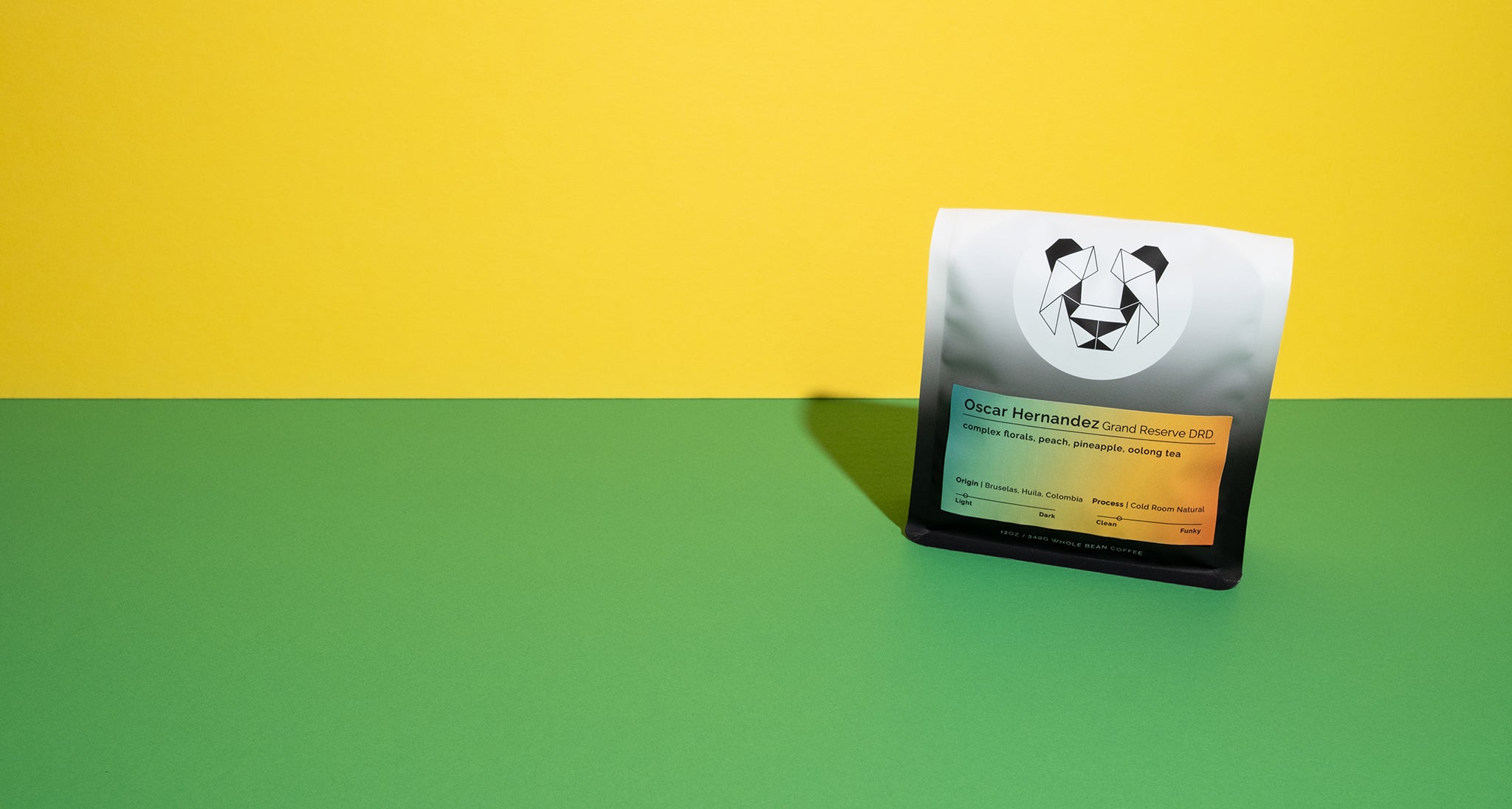 A bag of coffee with a panda design on a yellow and green background.