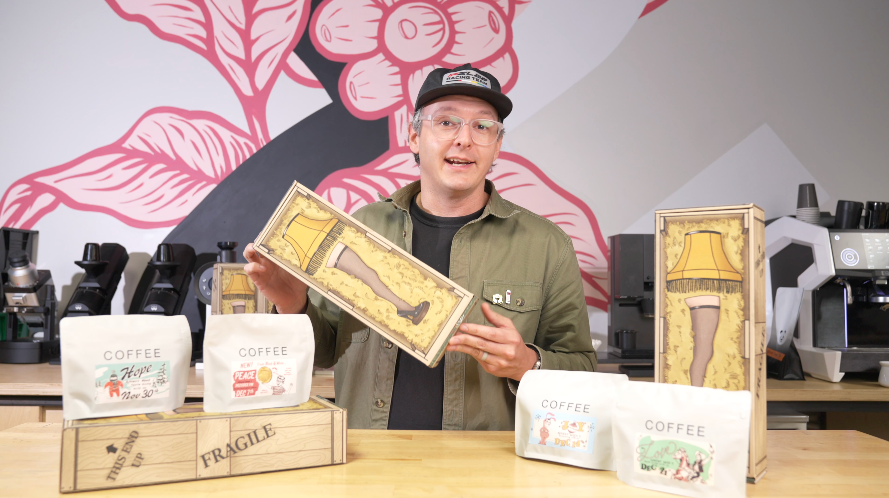 Man holding a coffee packaging box with a unique design in a coffee shop setting