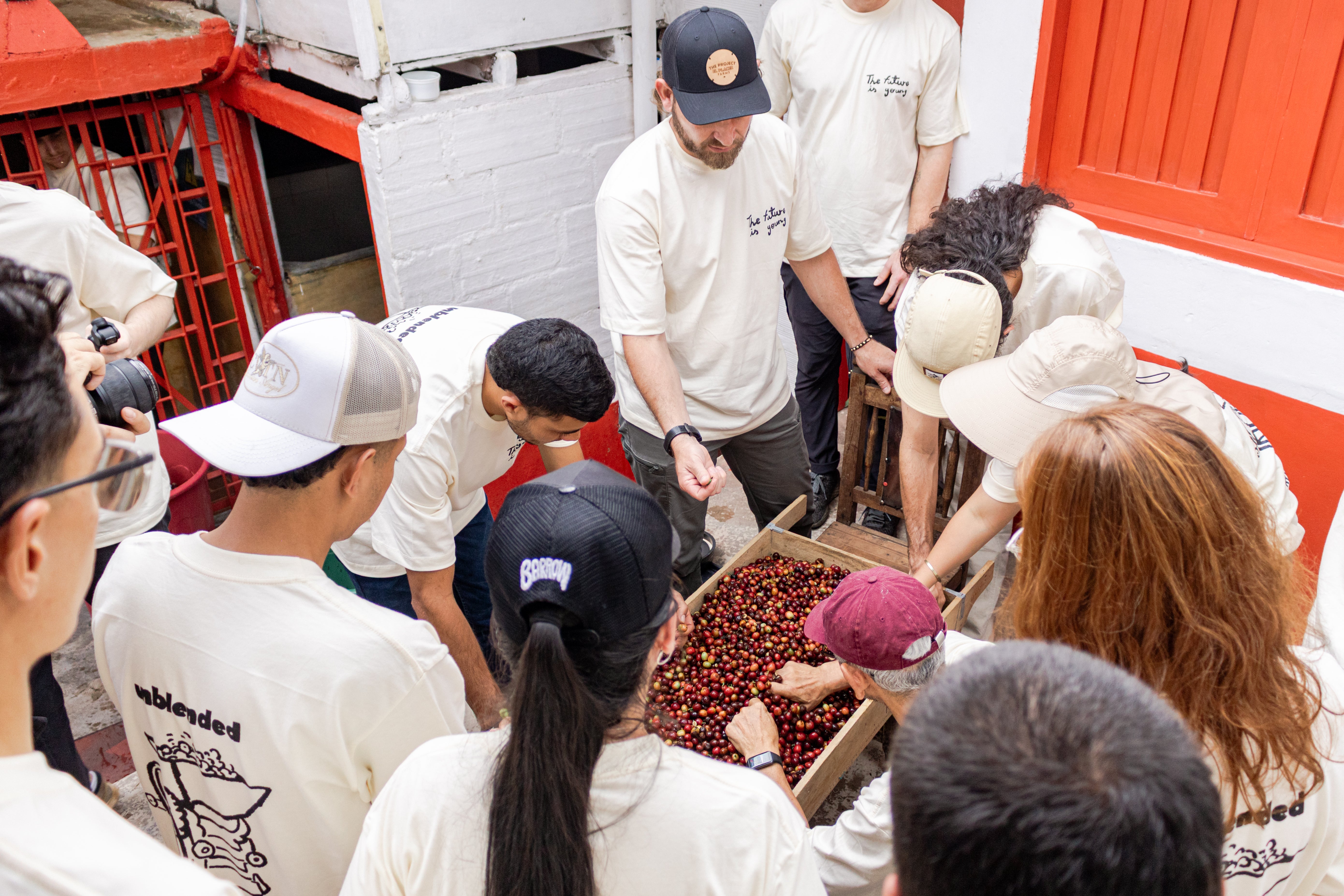 A group of young producers in Colombia, gathered around a pile of coffee cherries under the teaching of Sebastian Ramirez.